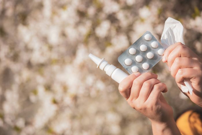 Person hält Tabletten und Nasenspray in der Hand. Es geht um neue Erkenntnisse bei der Allergiefrüherkennung. Bild ist von simon-kadula-p6z2jQCNYNU-unsplash